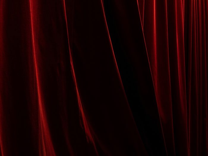 Rideaux de scène rouges fermés dans un théâtre ou une salle de spectacle